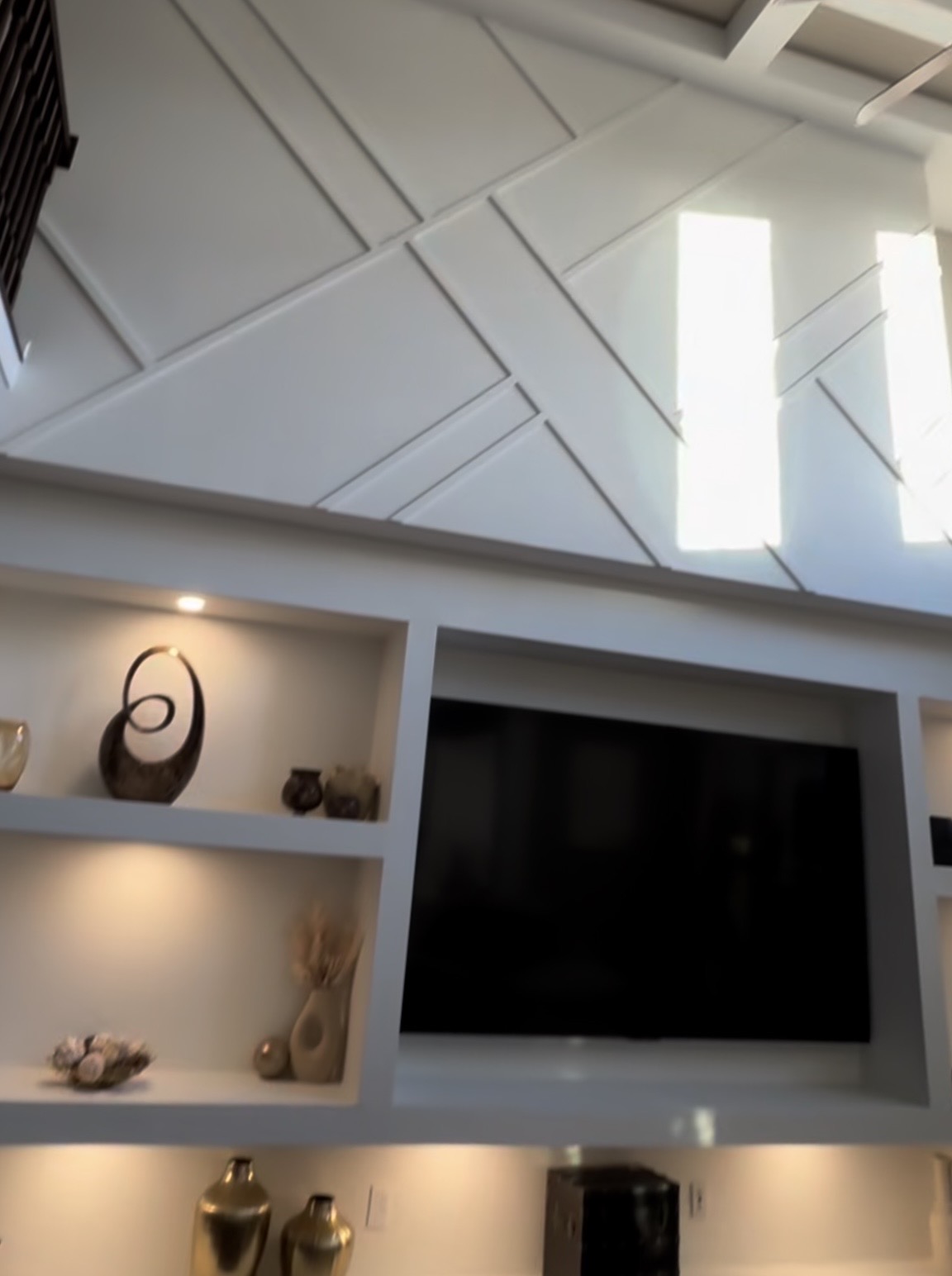 Discover how custom wall transformation with built-in shelving, adjustable LED lighting, and precision drywall finishing creates architectural focal points. Professional carpentry from studs out in Central Indiana.