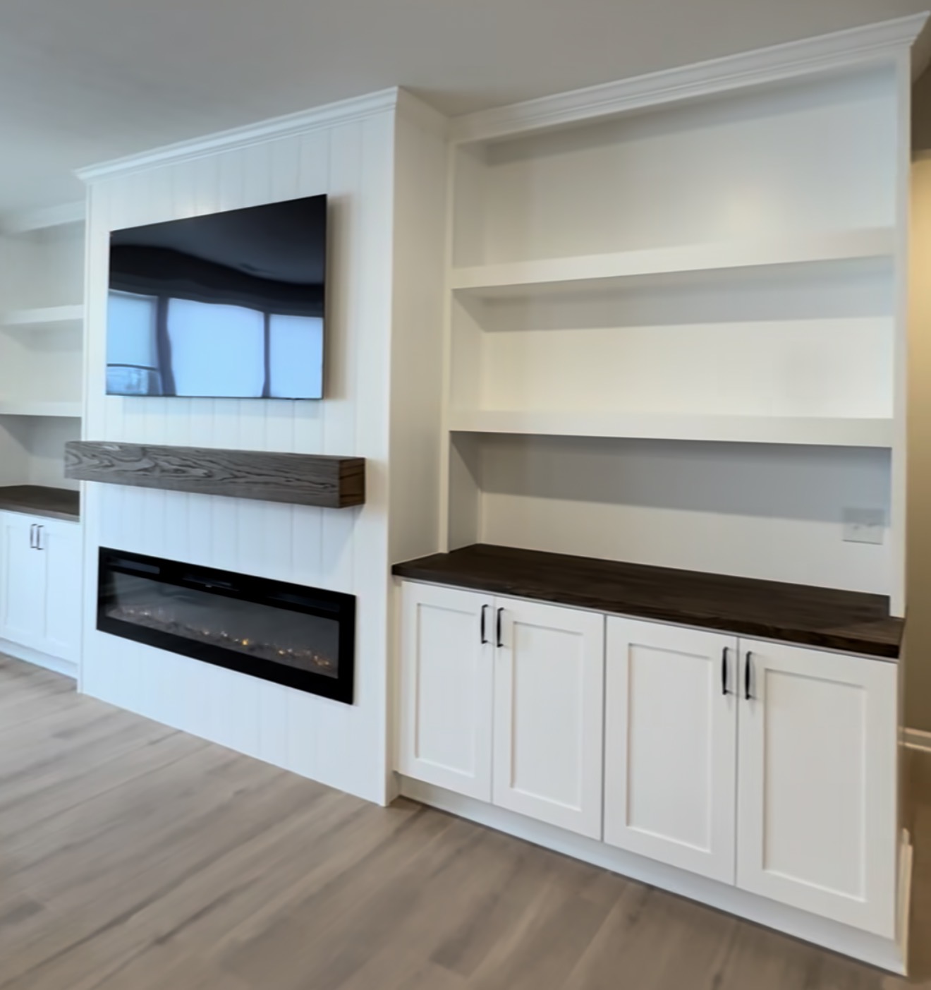 A behind-the-scenes look at a custom fireplace build-out in Westfield, Indiana — vertical shiplap, deep storage cabinets, a dark oak mantle, and a factory-level finish sprayed on-site. See why process drives the final result.