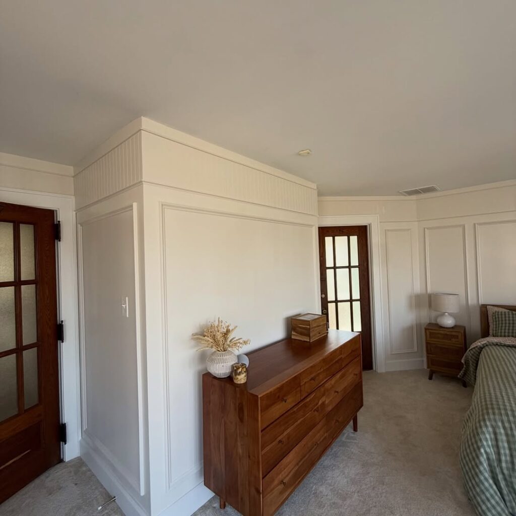 Molding brings quiet character to a primary suite through picture frame detail, beadboard, cove molding, trim carpentry, accent walls, and custom finish work.