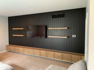 Indiana accent walls: black fluted panel wall behind a custom wet bar with X-frame wine storage and a floating wood shelf