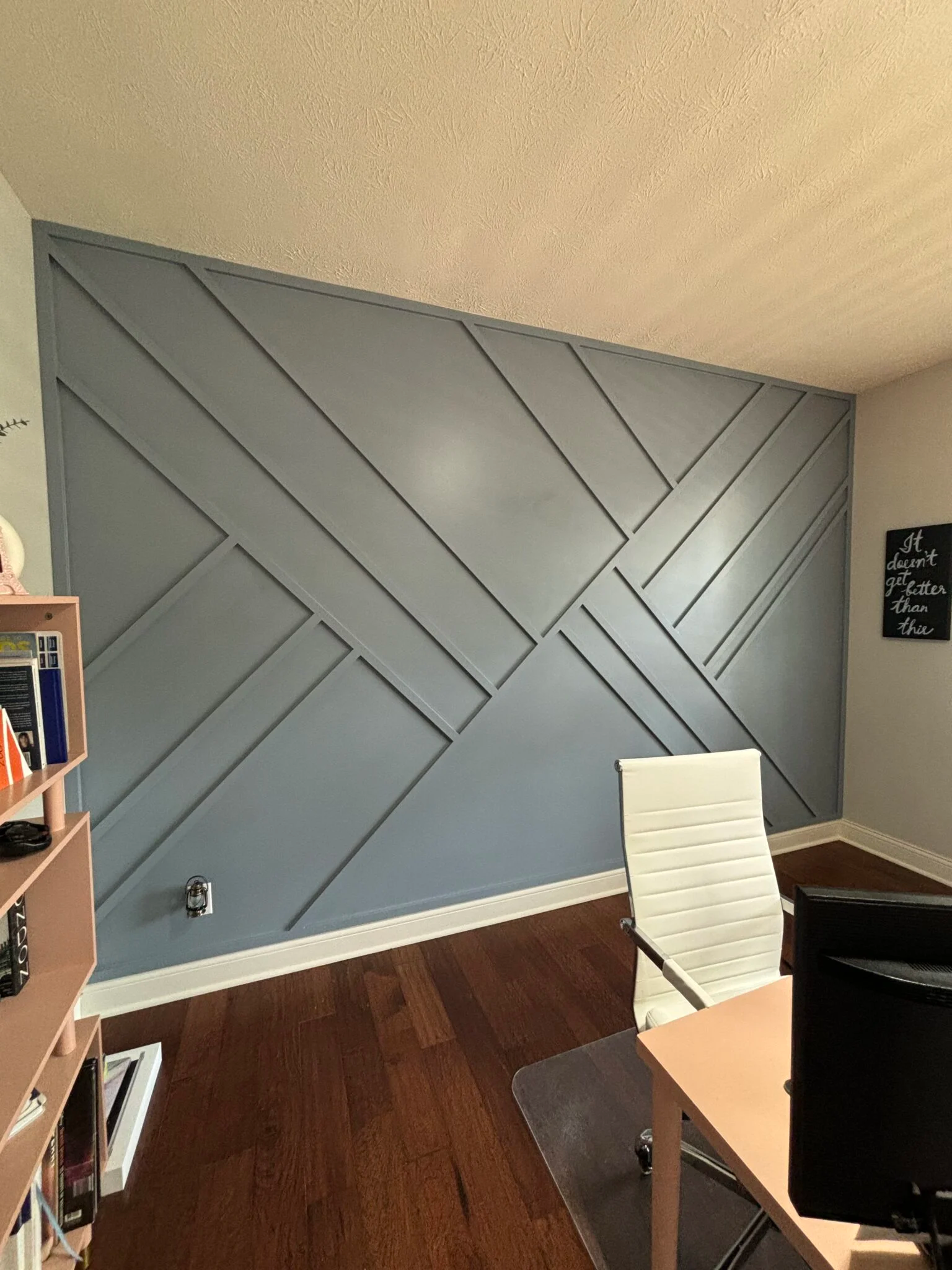 Black board and batten media wall with floating wood shelves and a built-in cabinet beneath the TV