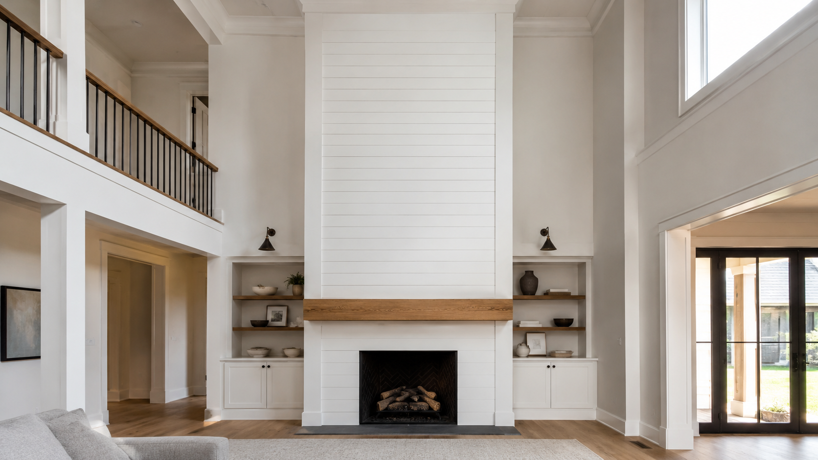 Two-story white shiplap fireplace wall with a solid oak mantle, black firebox, and built-in shelving on each side